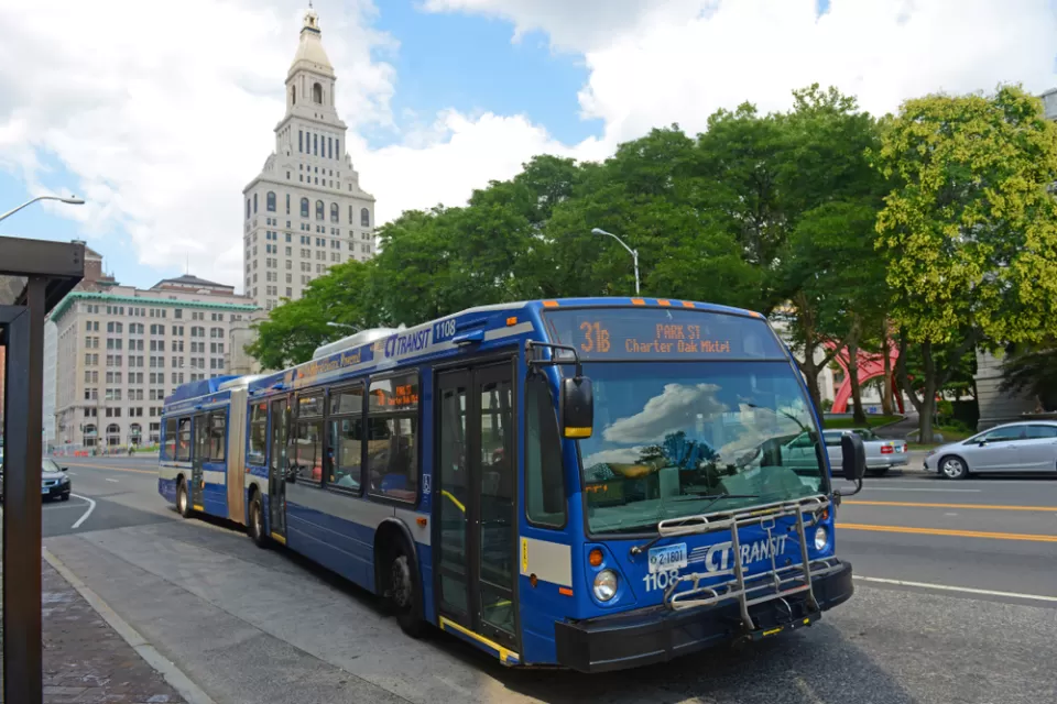 Blue CT Transit bus in Hartford, Connecticut with state capitol building in background